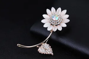 Dettaglio ravvicinato della spilla a girasole con brillanti strass e petali di gatto.