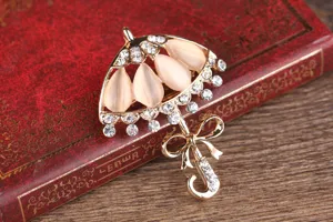 Elegante spilla a forma di ombrello con brillanti strass e pietre occhi di gatto chic.