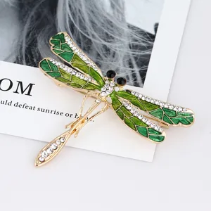 Close-up detail shot of an elegant green enamel dragonfly rhinestone brooch accessory.