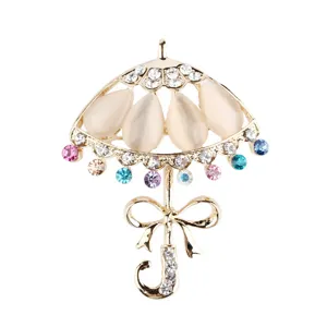 Elegante spilla a forma di ombrello con pietre occhio di gatto e strass colorati vista principale.