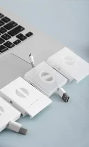 Gros plan de détail de l'enrouleur de câble portable et de la boîte de rangement sur le bureau.