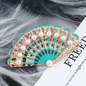 Spilla a ventaglio in perla vintage con smalto verde e strass, accessorio elegante.