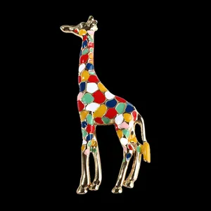 Close-up detail of the colorful enamel giraffe brooch showing vibrant gold plating and fine crafting.