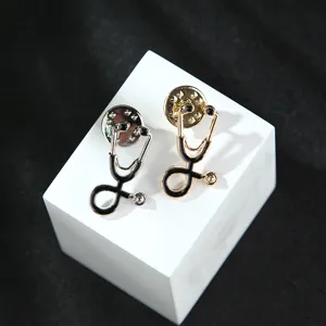 Stethoscope brooch detail close-up, alloy pin with black enamel accent, medical theme jewelry.