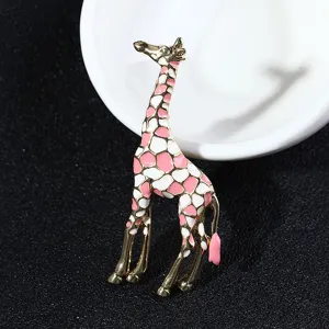 Exquisite gold-tone giraffe brooch with pink and white enamel spots, elegant accessory.