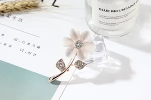 Exquisite cat eye stone flower brooch with sparkling rhinestones for elegant women.