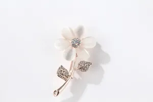 Close-up detail of a delicate cat's-eye stone flower brooch sparkling with rhinestones.