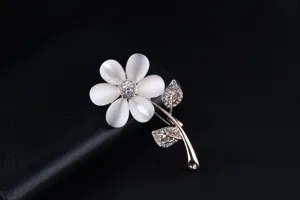 Close-up detail of a charming cat's eye stone flower brooch with sparkling rhinestone leaves.