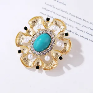 Detalle de un broche vintage barroco dorado con turquesa, perlas y brillantes strass.
