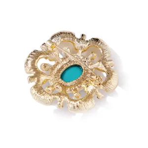Vista trasera detallada de un broche barroco vintage dorado con piedra turquesa ovalada.