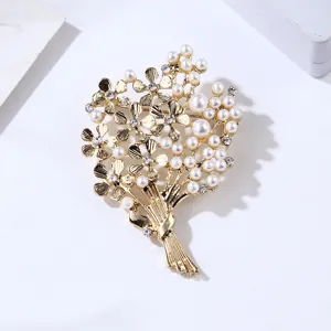 Gold tone pearl flower bouquet brooch detail close-up, elegant rhinestone fashion jewelry accessory.