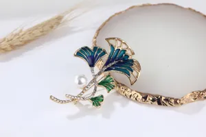 Exquisite ginkgo leaf brooch with pearls and rhinestones, elegant fashion clothing accessory.