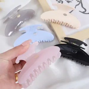 Detail view of stylish acetate hair claw clip in various colors, minimalist design.