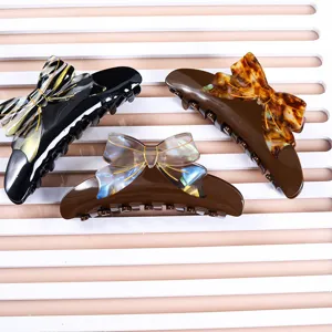 Acetate hair claw clips featuring elegant bow designs, perfect for secure and stylish updos.