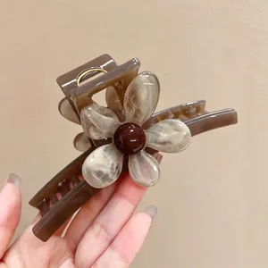 Detailaufnahme der eleganten braunen Haarspange mit Blumenmuster für schönes Styling.