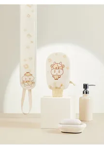 Vue détaillée du gant exfoliant motif vache et de la bande de douche dans un beau décor propre.
