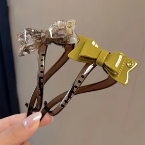 Primer plano detalle pinza de pelo con lazo de acetato, un elegante accesorio chic.