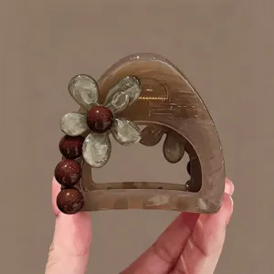 Nahaufnahme der braunen Blumen-Haarklammer mit Acrylblumen- und Perlendekoration im Detail.