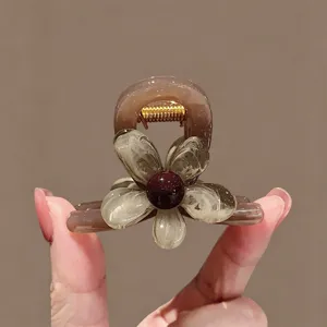 Detailansicht der braunen Blumen Haarklammer mit Kunstharz Blütenblättern und Metallfeder.