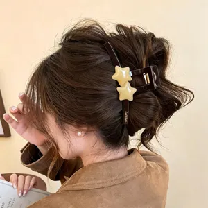 Detailansicht der braunen Stern-Haarklammer, elegantes Haarzubehör in Karamellton für dickes Haar.