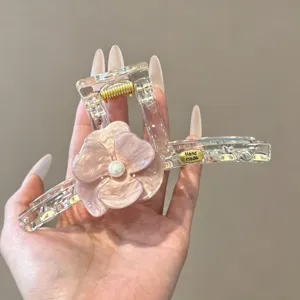 Detailansicht der Haarspange mit rosa Blume und Perle, hochwertiges Haarzubehör für Damen.