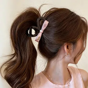Elegant pink bow hair claw clip for women, large shark clip for thick hair styling and daily wear.