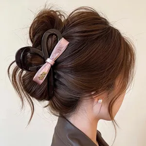 Detail view of a large black and pink bow hair claw clip, perfect for elegant hairstyles.