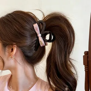 Pink bow hair claw clip for women, large shark clip with elegant ribbon design for thick hair.