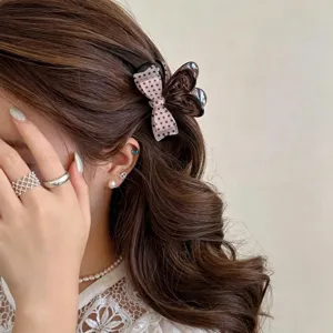 Small hair claw clip for women, cute bowknot design with polka dots, ideal for half-up hairstyles.