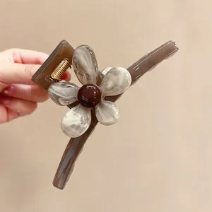Detailansicht der braunen Kunstharz Blumen Haarklammer mit feiner Blütenblattstruktur und robuster Feder.