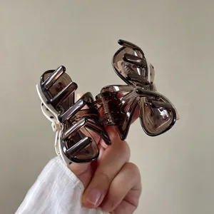 Brown transparent small bow hair claw detail, elegant hair accessory for half-up hairstyles.