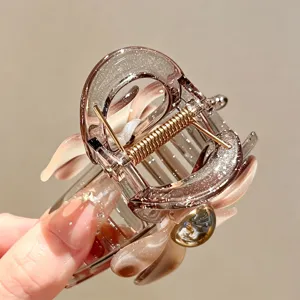 Detailansicht einer stilvollen glitzernden Blumen-Haarklammer, elegante große Haifisch-Klammer.