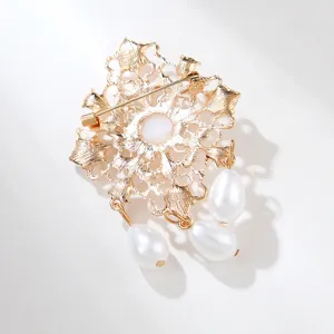 Gedetailleerd achteroverzicht van een vintage barok parelbroche met prachtig gouden metaalwerk.