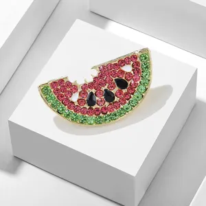 Detailopname van een stralende watermeloen broche met kleurrijke strass kristalstenen.