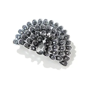 Gedetailleerd overzicht van vintage zilverkleurige pauwenbroche met sprankelende zwarte strass.