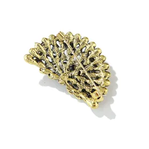 Achterste detailweergave van vintage goudkleurige pauw broche, opengewerkt metaal.