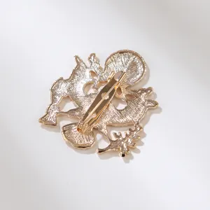 Metal brooch back detail view, gold tone finish, secure safety pin clasp, close-up shot.