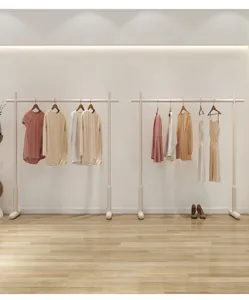 Detailed view of modern minimalist standing clothes rack, elegant light color design.