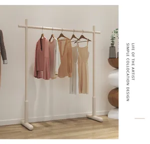 Detailed view of modern minimalist clothes rack showcasing hanging garments in cozy room.