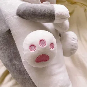 Gros plan détaillé d'une jolie peluche de chien requin avec des pattes roses brodées.