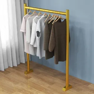 Modern gold standing clothing rack for bedroom, space-saving garment display stand.