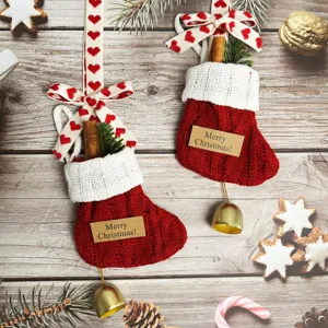 Detailed view of red knit Christmas stockings with bells and ribbons for holiday decor.