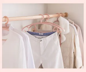 Pink plastic clothes hangers with wide shoulders for home wardrobe storage and laundry drying.