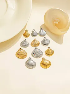 Gros plan sur les pendentifs coquillage en acier inoxydable doré et argenté pour bijoux.