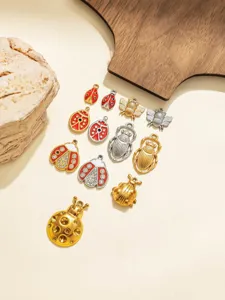 Close-up details of assorted vintage insect pendants, ladybugs, bees, and beetle charms.