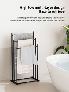 Modern black metal floor-standing towel rack with multi-layer staggered design for bathroom.
