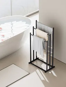 Bathroom detail view of a modern black metal freestanding multi-tier towel rack in a sleek scene.