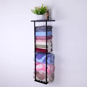 Wall-mounted metal storage rack for bathroom kitchen towel organization with plant decor.