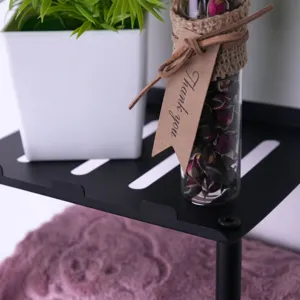 Detailed close-up of the black metal storage shelf, showing matte texture and slats.