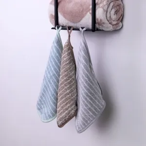 Wall-mounted metal storage rack with hanging striped towels for bathroom and kitchen use detail.
